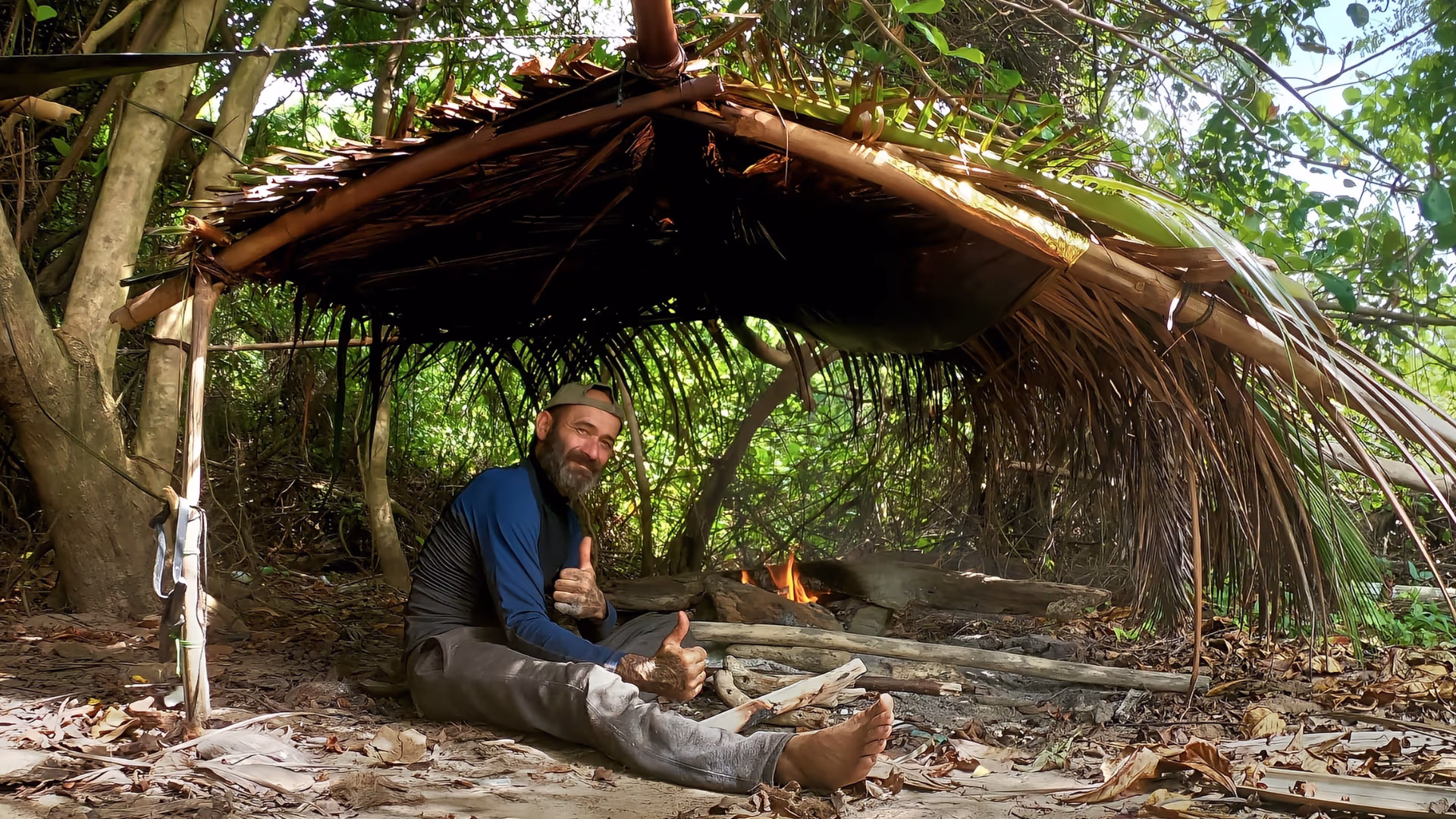 Un homme assis sous un abris de fortune 